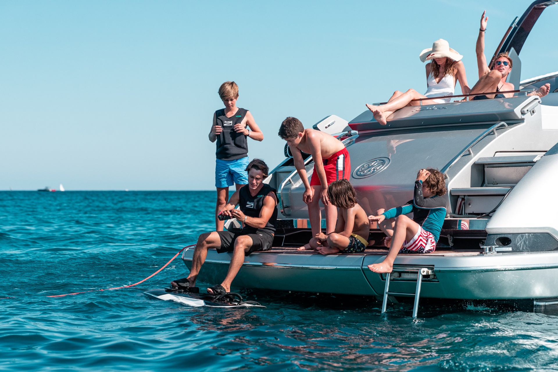 Family enjoying an Awake RÄVIK electric jetboard from the swim platform of a luxury motor yacht