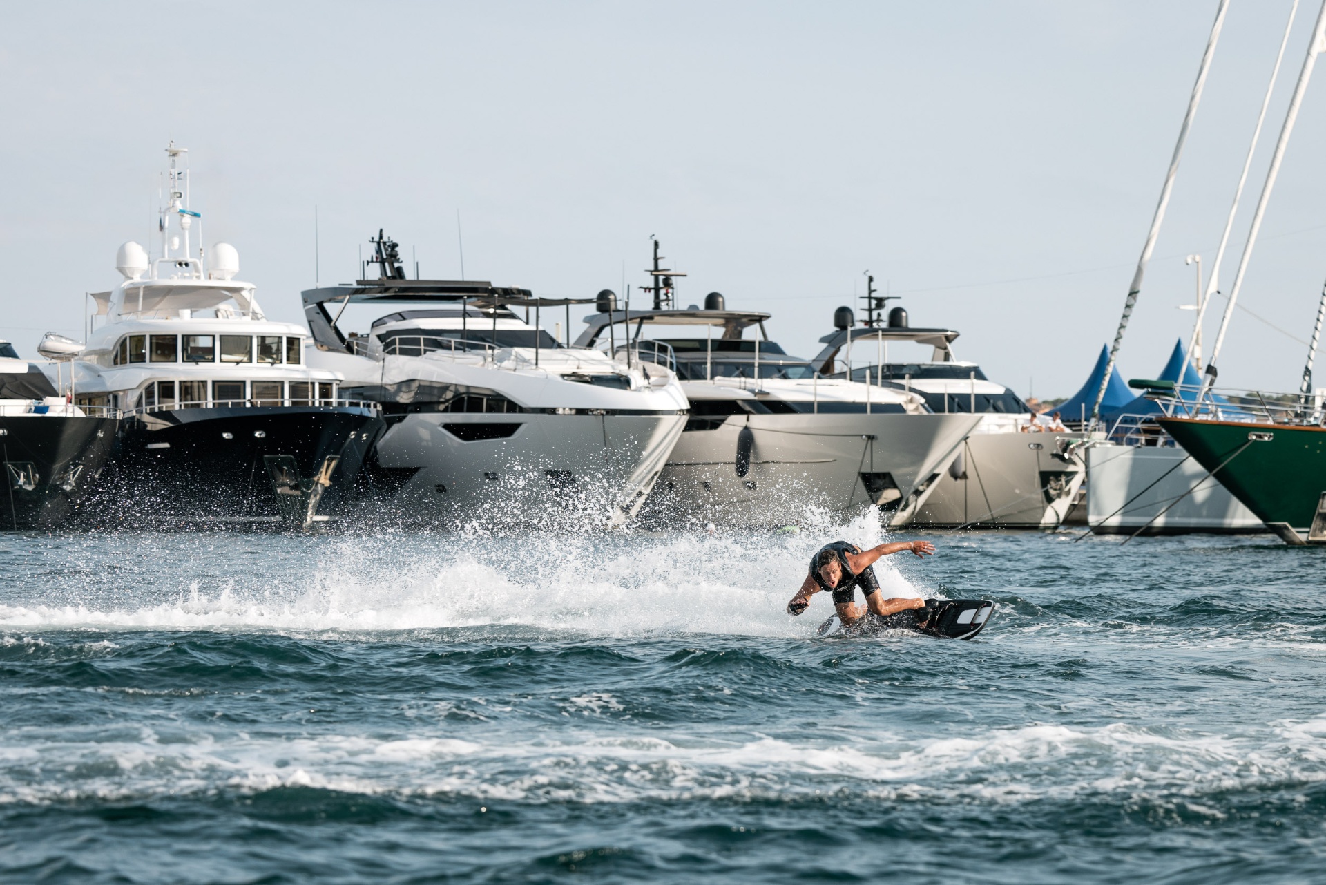 Awake RÄVIK rider carving in front of superyachts in a marina
